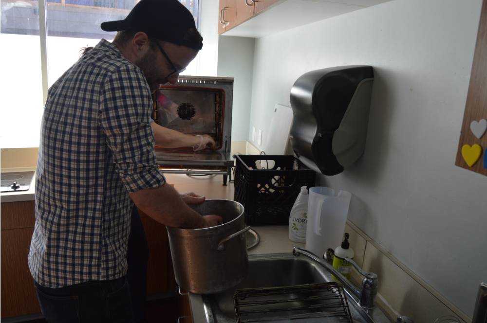 Alumnus washing dishes